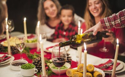 Des personnes sont installées à tables et se servent à boire pour célébrer une communion