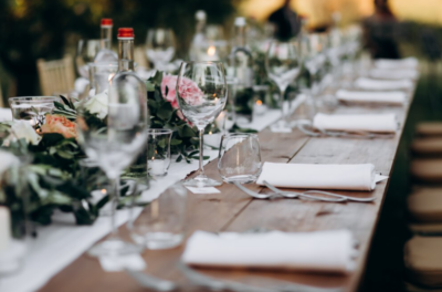 Une table ornée de fleurs est dréssée avec de la vaisselle pour un mariage